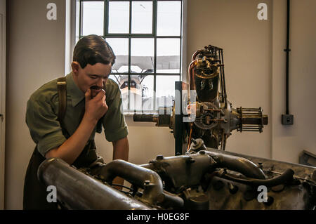 Das Museum auf dem Stow Maries Erster Weltkrieg Flugplatz in Essex, England. Eine Schaufensterpuppe Ingenieur studiert ein Flugzeugtriebwerk Stockfoto