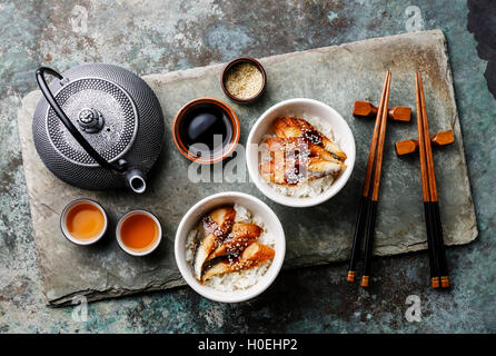 Aal auf Reis mit Sauce und Sesam zu zweit auf Stein Schiefer Hintergrund und Tee Stockfoto