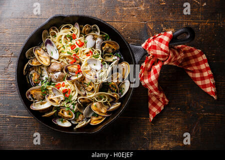 Spaghetti Alle Vongole Meeresfrüchte Pasta mit Muscheln in Gusseisen Pfanne auf hölzernen Hintergrund Stockfoto