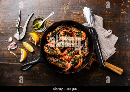 Tiger Garnelen Garnelen gebraten auf Grill Bratpfanne mit grüner Sauce, Zitrone und Knoblauch auf hölzernen Hintergrund Stockfoto