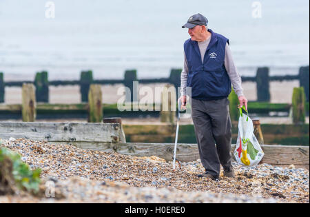 Älterer Mann Abholung Wurf von einem Strand entfernt. Stockfoto