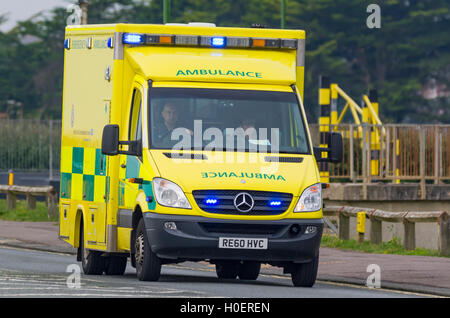 Krankenwagen mit blauen Lichtern auf einer Straße in Großbritannien. NHS Ambulance UK. Blaues Licht im Krankenwagen. Rettungsdienst. Mercedes Benz Sprinter von 2011. Stockfoto
