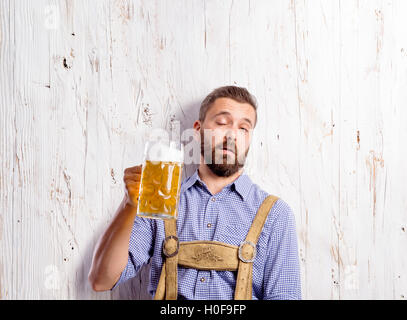 Betrunkener Mann in bayerischer Tracht halten Bierkrüge Stockfoto