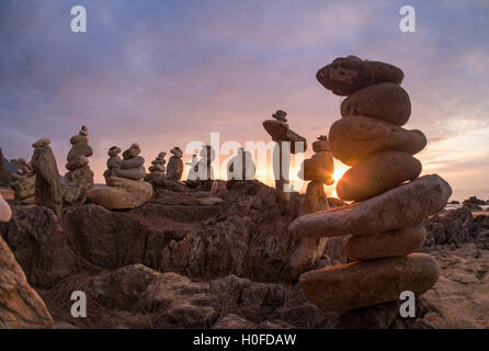 Steinen Pyramide auf Sand als Symbol für Zen, Harmonie und Balance. Meer bei Sonnenuntergang in Khao Lak Thailand Stockfoto