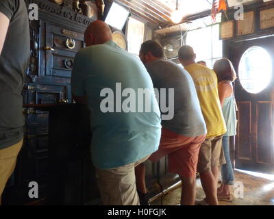 Gäste in bunten Hemden schlanke über bar und trinken Bier Stockfoto