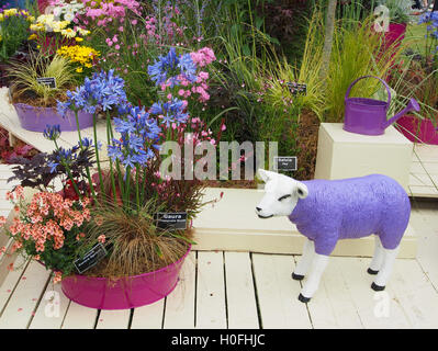 Anzeige der verschiedenen Blumen in Töpfen mit einem lila Fiberglas Schaf an Tatton Park Flower Show 2016 in Cheshire, England. Stockfoto