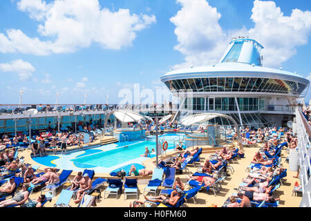 Passagiere genießen Sie die mediterrane Sonne auf dem Pooldeck ein Thomson Kreuzfahrtschiff. Stockfoto