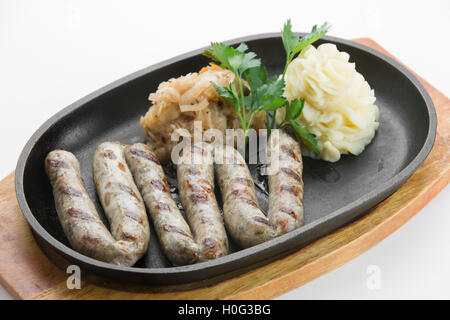 Aus der Türkei Kalbfleisch gebraten mit Paprika Wurst in schwarze Pfanne auf Holzbrett Stockfoto
