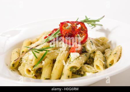 Penne-Nudeln mit Feta Käse, Spinat, Pesto und getrockneten Tomaten Stockfoto