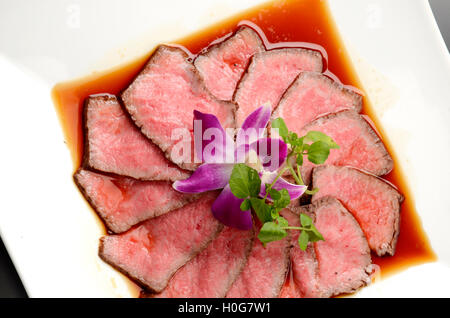 Frisch gebratenes Rindfleisch auf weißen Teller mit Kräutern im restaurant Stockfoto