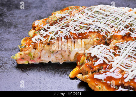Traditionelle japanische Okonomiyaki Pfannkuchen auf heiße schwarze Pfanne Stockfoto
