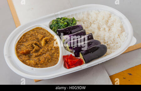 Lunch-Box von gebratenen Auberginen, Spinat, Curry mit Chili und Reis Stockfoto