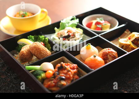 Bento von Temari Sushi, Garnelen und marinierten Pilzen, Ei, Grilltomate, Frühlingsgemüse, Rindfleisch und Spargel Kroketten, boi Stockfoto