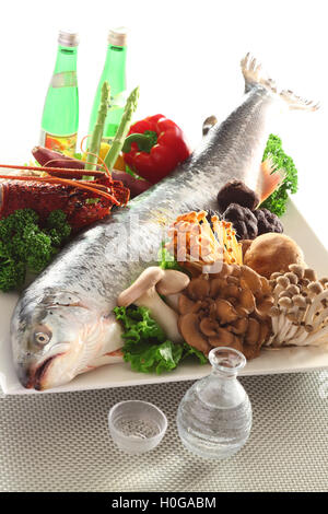 Frischer ganzer Lachs mit Champignons, Brokkoli, Chili und Öl in der Küche Stockfoto