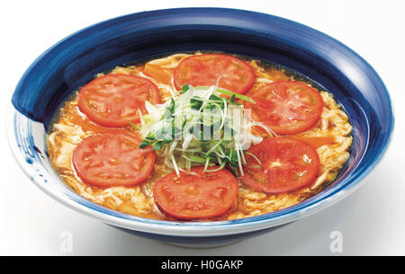 Leckeres Ei Suppe mit in Scheiben geschnittenen Tomaten und Zwiebel Kräuter in große chinesische Schüssel auf weißem Hintergrund Stockfoto