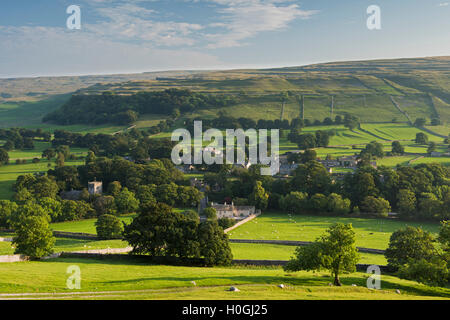 Sommer Abend Blick auf malerische Dales Dorf Arncliffe (Kirche & Häuser) eingebettet im Tal unter sonnenbeschienenen Hügeln - North Yorkshire, England, Großbritannien Stockfoto