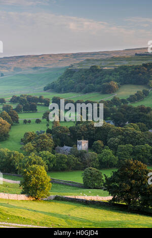 Sommer Abend Blick auf Kirche (und Turm) im malerischen Dales Dorf im Tal unter sonnenbeschienenen Hügeln - Arncliffe, North Yorkshire, England, UK eingebettet Stockfoto