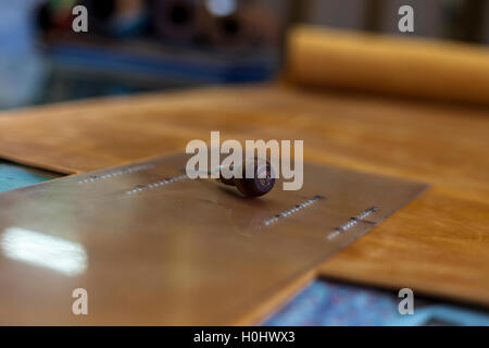 Buchbinder-Tool und gestreckten Roll aus Leder. Stockfoto