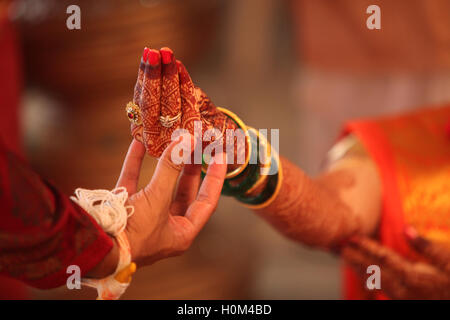 Eine indische Bräutigam an die Braut Hand während einer traditionellen hindu-Hochzeit Rituals Stockfoto