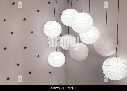 Laternen, die von der Decke hängen, an der Wand der Sterne im Raum Stockfoto