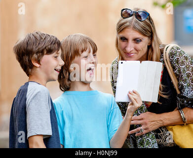 Zwei jungen zeigen etwas Mutter auf Tablet Stockfoto