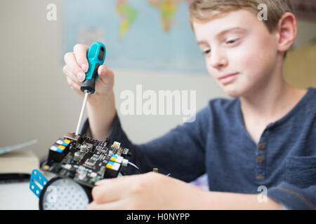 Junge Montage Roboter Kit im Schlafzimmer Stockfoto