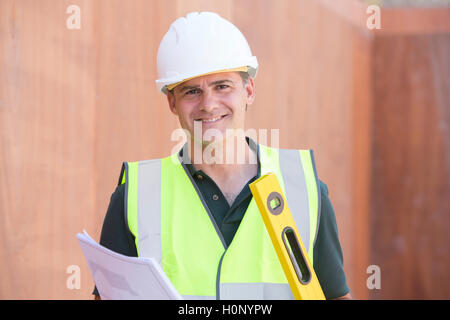 Porträt der Bauarbeiter auf der Baustelle mit Haus Pläne Stockfoto