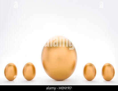 Anlagekonzept mit großen und kleinen goldenen Eiern Stockfoto