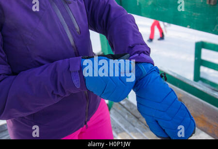 Eine Frau in lila Jacke Kleid blaue Handschuhe an den Händen Stockfoto