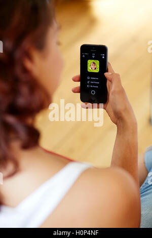 Mädchen mit Snapchat app auf ihrem iPhone Stockfoto