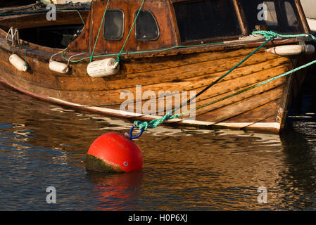 Kleines Holzboot vor Anker in den geschützten Gewässern der Hafen von West Bay auf jurassic Küste Dorsets Stockfoto