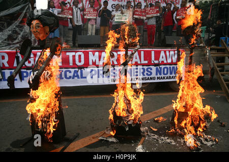 Manila, Philippinen. 21. Sep, 2016. Die Bildnisse von Imelda Marcos, ehemaliger Präsident Ferdinand Marcos, und ihr Sohn Ferdinand "Bongbong" Marcos Jr. brennt in Mendiola Manila. Hunderte von Demonstranten besetzt Mendiola Brücke in Manila, wie sie den 44. Jahrestag des Kriegsrechts erinnern. Tausende wurden entführt, gefoltert und getötet während der Jahre kriegerisches Gesetz, die Ferdinand Marcos auferlegt, um die angeblichen Gesetzlosigkeit in den 70-er Jahren Einhalt zu Gebieten. Bildnachweis: J Gerard Seguia/Pacific Press/Alamy Live-Nachrichten Stockfoto