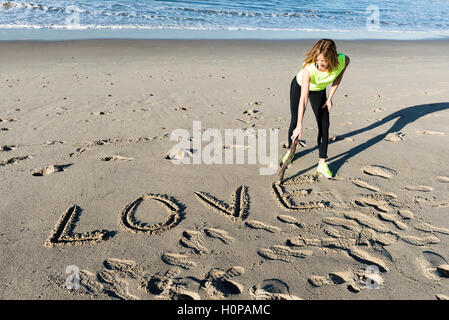 Das Wort Liebe geschrieben am Strandsand Stockfoto