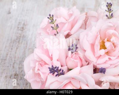 Blass rosa Rosen und Lavendel Strauß auf das weiß lackiert rustikal Hintergrund Stockfoto