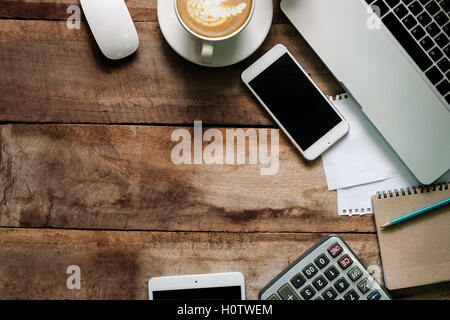 Büro-Zeug mit Smartphone-Laptop Tablet und Kaffee Tasse Maus Editor Ansicht von oben geschossen. Stockfoto