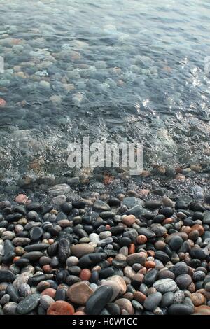 Kiesstrand mit klarem Wasser Stockfoto