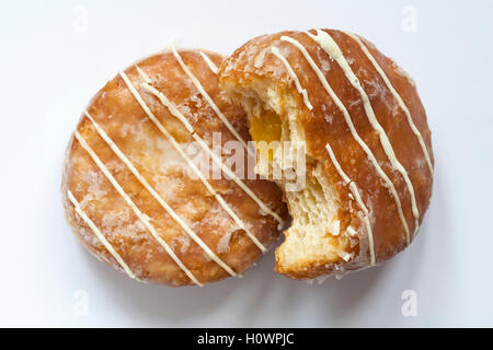 M & S Passionsfrucht Yum Yums iced Krapfen, die man in gebissen auf weißem Hintergrund isoliert Stockfoto