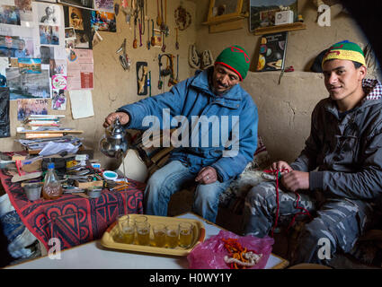 Dades Schlucht, Marokko.  Berber Mann mittleren Alters und 19 Jahre alten Sohn Gießen Tee für die Gäste. Stockfoto