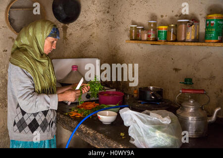 Dades Schlucht, Marokko.  Mittleren Alters Berber Frau Vorbereitung Abendessen in ihrer Küche. Stockfoto