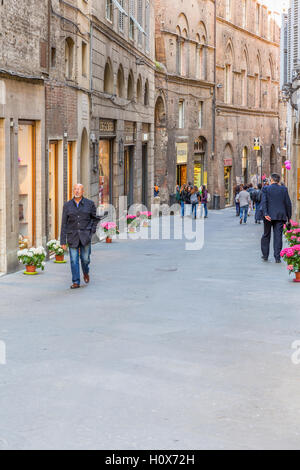 Menschen zu Fuß auf einer Straße in der Stadt Siena in Italien Stockfoto