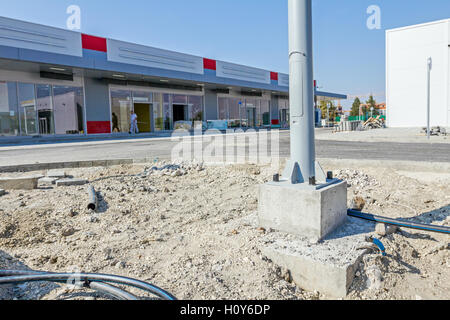 Verbindungselemente - Schrauben und Muttern auf quadratischen Betonsockel von elektrischen Metall Laterne. Stockfoto