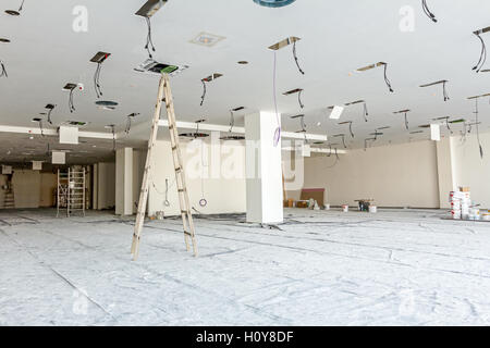 Arbeitnehmer dienen Holzleiter, komplette Klimaanlage System Ventilation im modernen Office-Decke mit Luftkanal und Lampen. Stockfoto