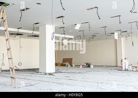 Arbeitnehmer dienen Holzleiter, komplette Klimaanlage System Ventilation im modernen Office-Decke mit Luftkanal und Lampen. Stockfoto