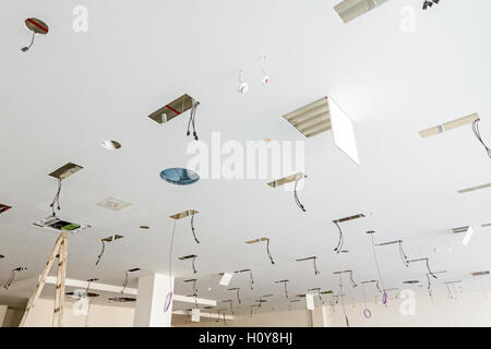 Arbeitnehmer dienen Holzleiter, komplette Klimaanlage System Ventilation im modernen Office-Decke mit Luftkanal und Lampen. Stockfoto