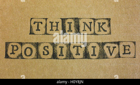 Worte denke positiv machen, indem schwarze Alphabet Stempel auf Karton. Stockfoto