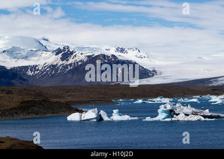 die Gletscherlagune Jökulsárlón mit Eisbergen und Breidamerkurjokull Gletscher mit Gletschermoränen Süden Islands Stockfoto
