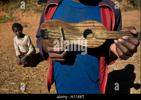 Junge mit Gitarre (Madagaskar). Er gehört zur Volksgruppe Betsileo. Stockfoto