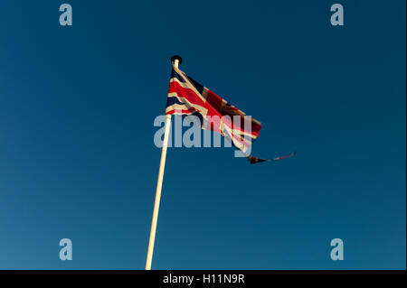 Zerrissene Union Jack-Flagge gegen blauen Himmel Stockfoto