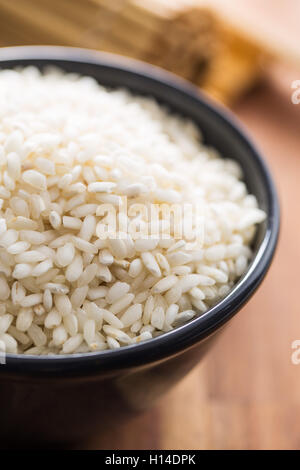 Arborio-Reis in Schüssel auf Holztisch. Stockfoto