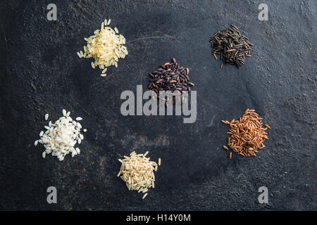 Verschiedene Reissorten auf alten Tisch. Ansicht von oben. Stockfoto